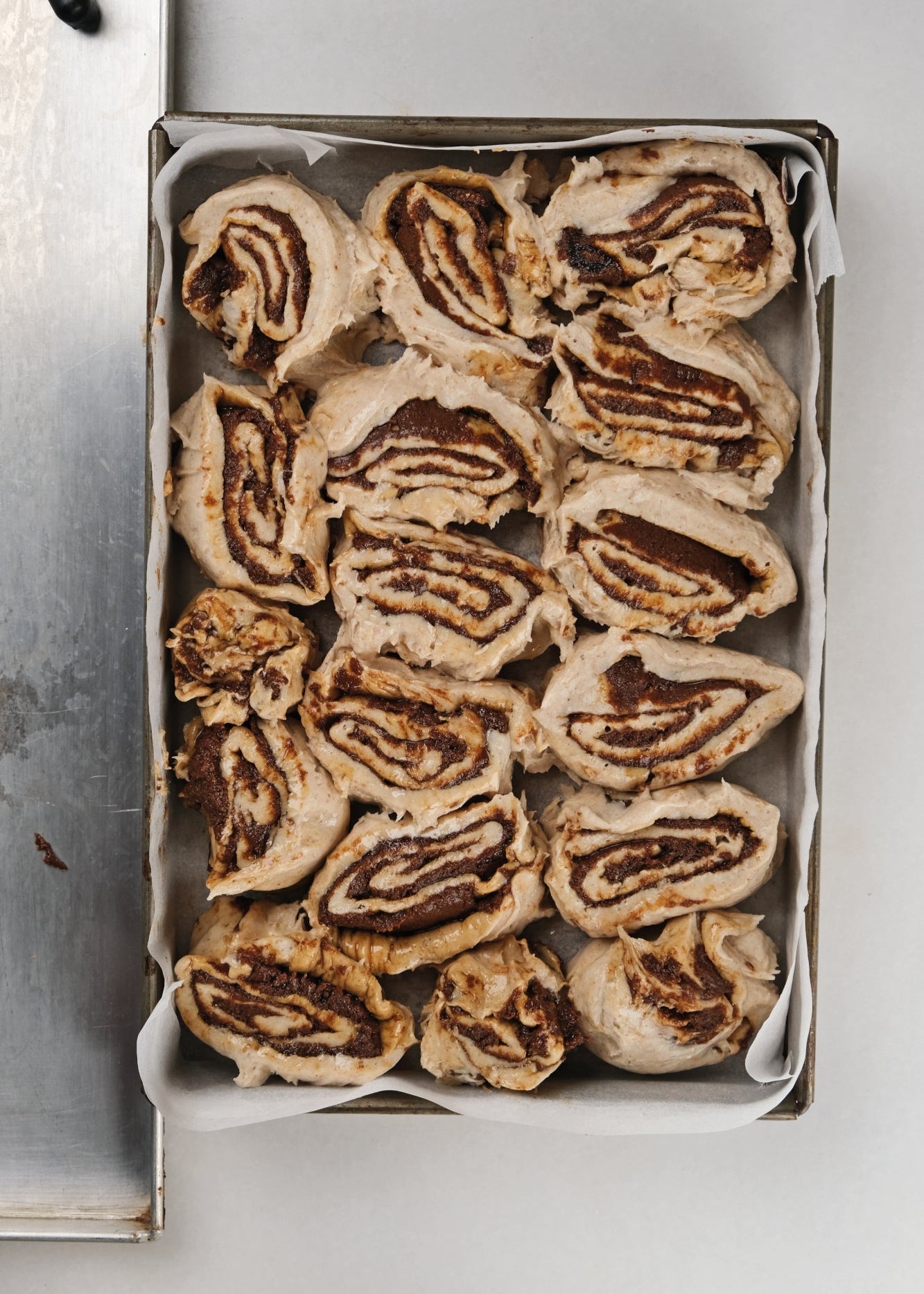 rolls sin gluten y veganos de canela en una bandeja para entrar al horno