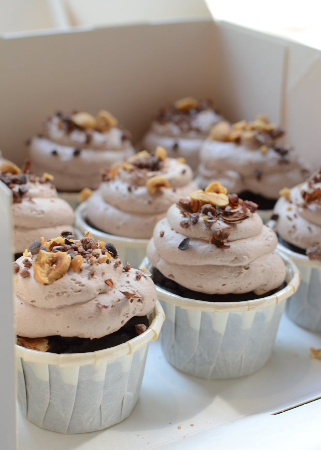 Caja con cupcakes de cacao decorados con trufa vegana y sin gluten.